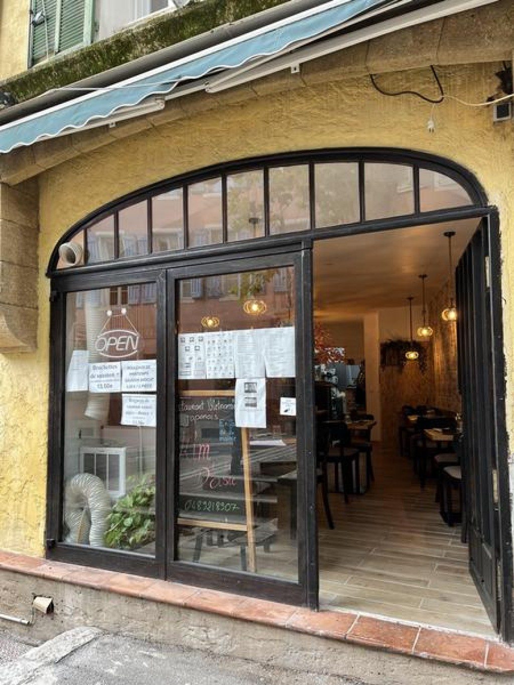 La devanture vitrée du restaurant Kim d'Asie, sous une arcade de la place Capitaine Vincens