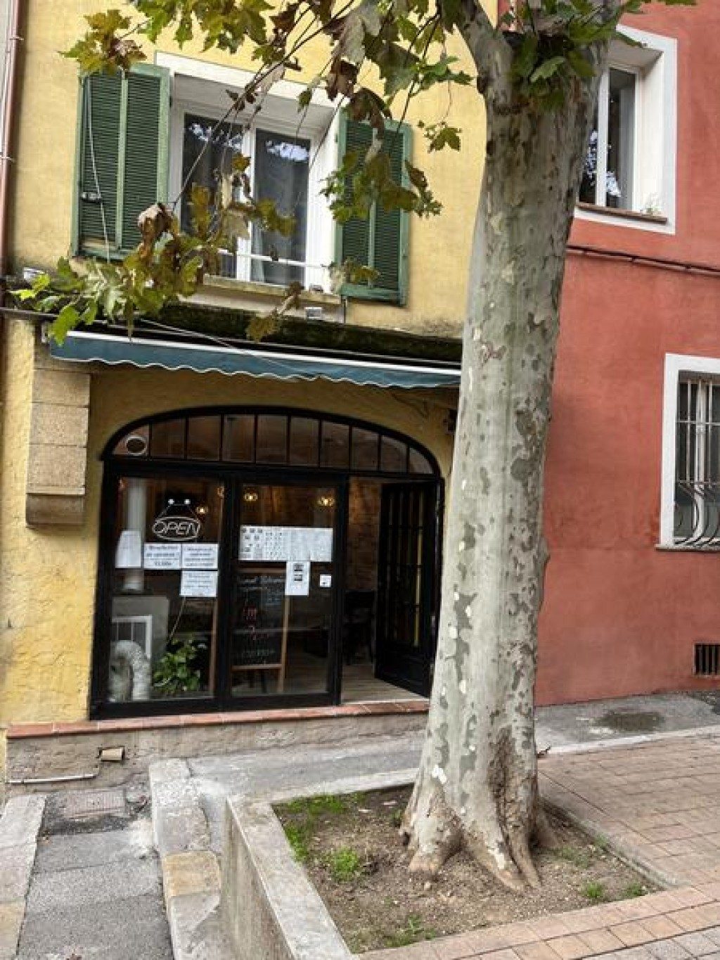Le restaurant vu de la place, devant un platane